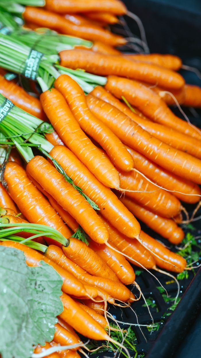 Close-up of freshly harvested carrots neatly stacked, showcasing vibrant color and healthy produce.